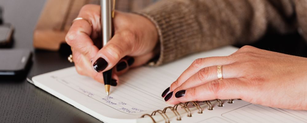 person writing in a journal on how leaders can use transparency
